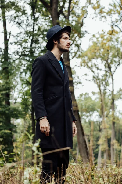 Young man with black hat in forest — Stock Photo, Image