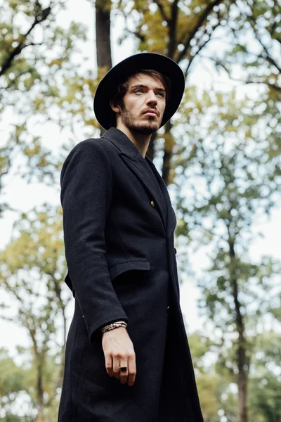 Young man with black hat in forest — Stock Photo, Image