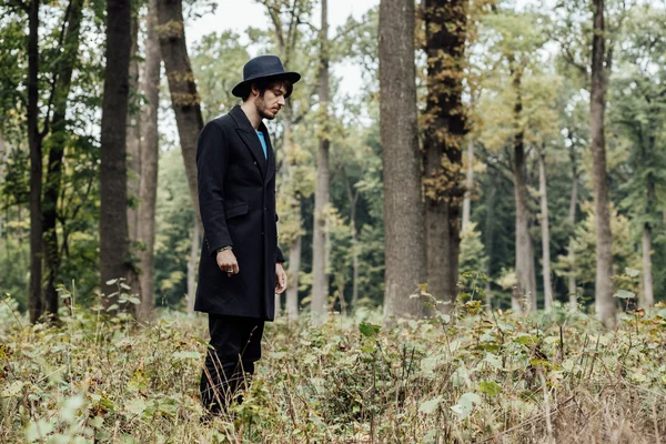 Joven con sombrero negro en el bosque —  Fotos de Stock