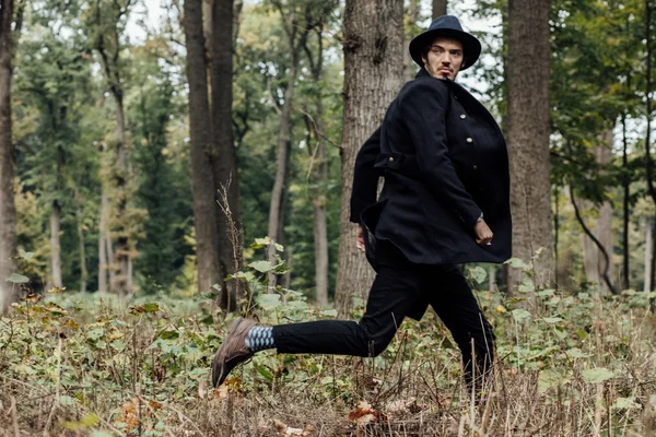 Joven con sombrero negro en el bosque —  Fotos de Stock