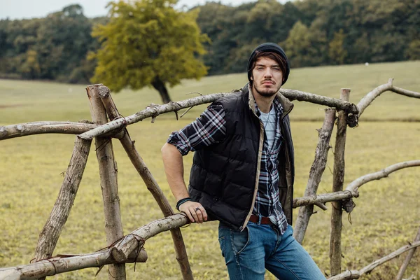 Giovane vicino a una recinzione di legno — Foto Stock