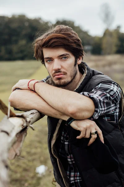 木製のフェンスの横に若い男 — ストック写真