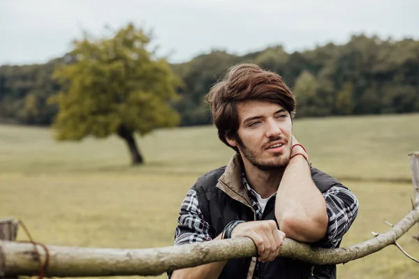 Junger Mann neben einem Holzzaun — Stockfoto