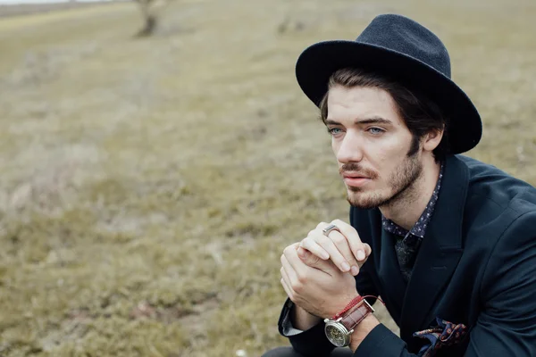 Uomo elegante su un campo verde — Foto Stock