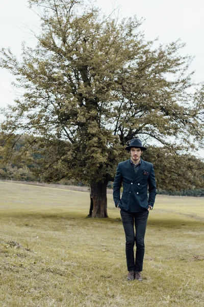 Stylish man on a green field — Stock Photo, Image