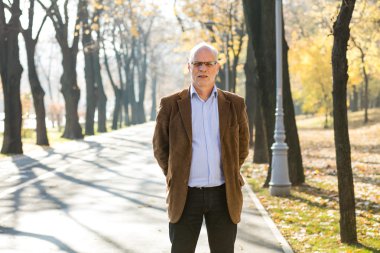 Dışarıda duran yaşlı adam şık giyinmiş