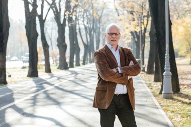 Dışarıda duran yaşlı adam şık giyinmiş