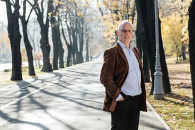 Dışarıda duran yaşlı adam şık giyinmiş