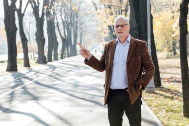 Dışarıda duran yaşlı adam şık giyinmiş