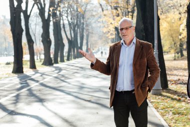 Dışarıda duran yaşlı adam şık giyinmiş