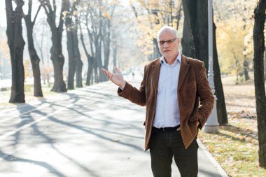 Dışarıda duran yaşlı adam şık giyinmiş