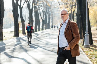 Dışarıda duran yaşlı adam şık giyinmiş