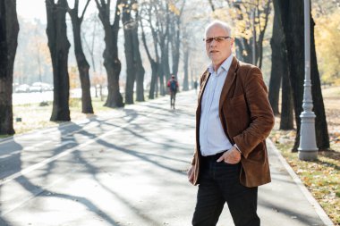 Dışarıda duran yaşlı adam şık giyinmiş