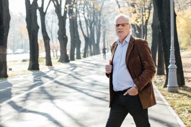 Dışarıda duran yaşlı adam şık giyinmiş