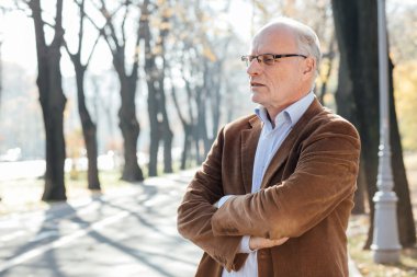 Dışarıda duran yaşlı adam şık giyinmiş