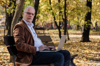 bir bankta dışında dizüstü çalışan eski iş adamları