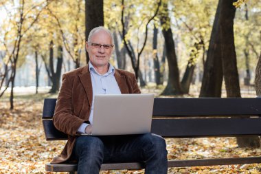 bir bankta dışında dizüstü çalışan eski iş adamları