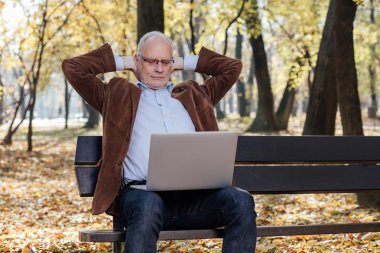 bir bankta dışında dizüstü çalışan eski iş adamları