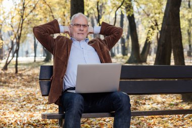 bir bankta dışında dizüstü çalışan eski iş adamları