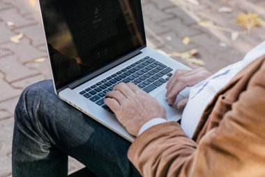 bir bankta dışında dizüstü çalışan eski iş adamları