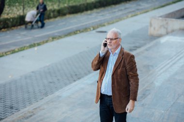 Dışarıda yetişkin kişi gri saçlı şık giyinmiş