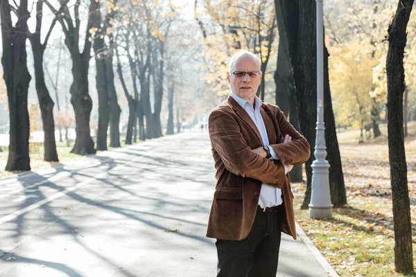 Dışarıda duran yaşlı adam şık giyinmiş