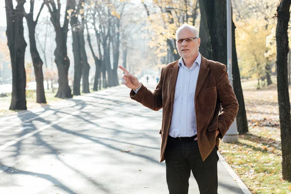 Dışarıda duran yaşlı adam şık giyinmiş