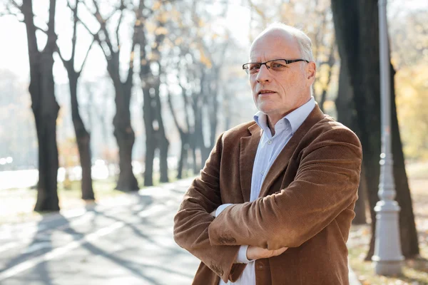 Dışarıda duran yaşlı adam şık giyinmiş