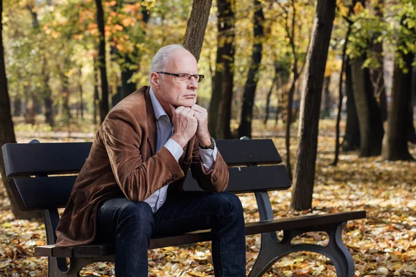 Velho homem elegante sentado no banco fora — Fotografia de Stock