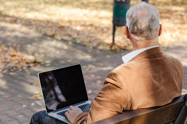 bir bankta dışında dizüstü çalışan eski iş adamları