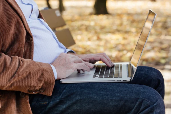 bir bankta dışında dizüstü çalışan eski iş adamları