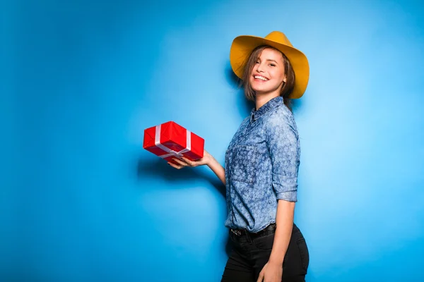 Fiatal nő piros ajándék tartja kezében — Stock Fotó