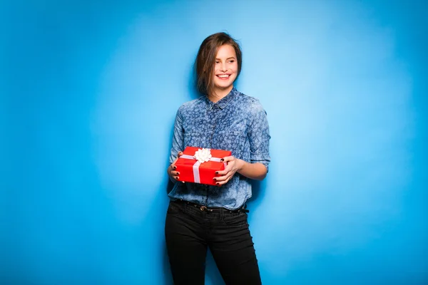 Fiatal nő piros ajándék tartja kezében — Stock Fotó