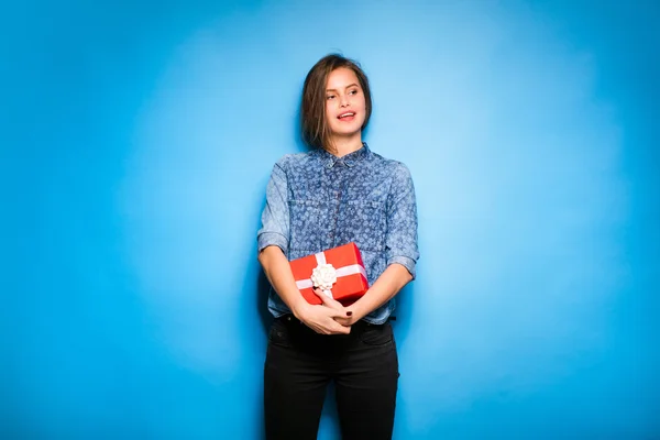 Young woman holding red gift in hands — Stock Photo, Image