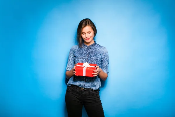 Jeune femme tenant cadeau rouge dans les mains — Photo