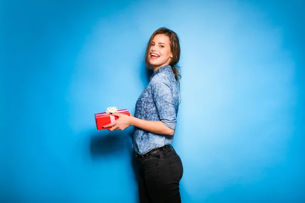 Mujer joven sosteniendo regalo rojo en las manos —  Fotos de Stock