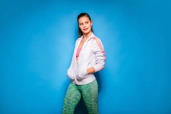 Young athletic woman in hoodie on blue background — Stock Photo, Image