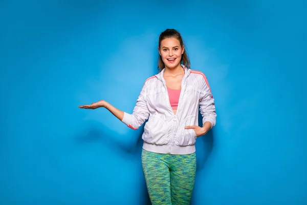 Joven atlética mujer en sudadera con capucha sobre fondo azul —  Fotos de Stock