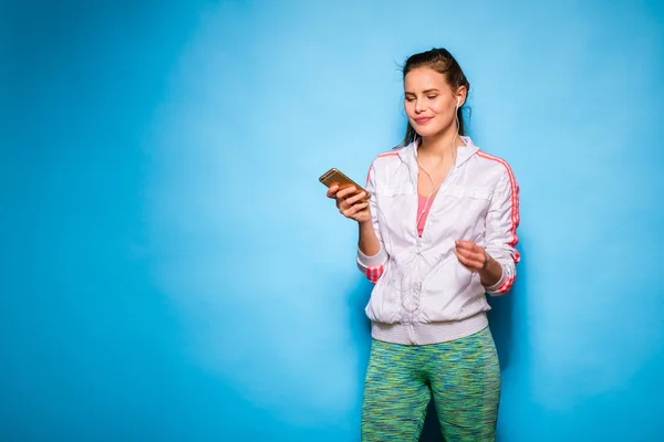Young athletic woman with cellphone — Stock Photo, Image