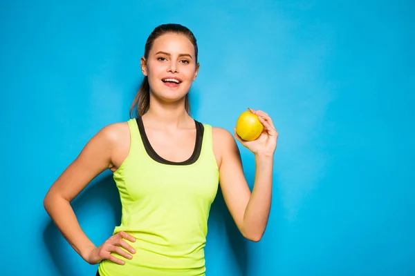 リンゴを手に保持しているスポーツ機器のきれいな女性 — ストック写真