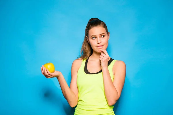 Bonita mujer en equipo deportivo sosteniendo una manzana en la mano — Foto de Stock