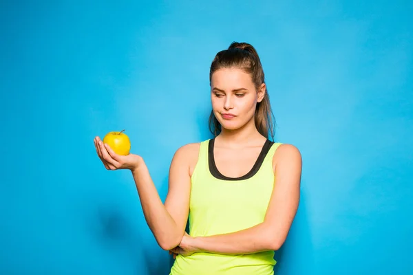 Bonita mujer en equipo deportivo sosteniendo una manzana en la mano — Foto de Stock