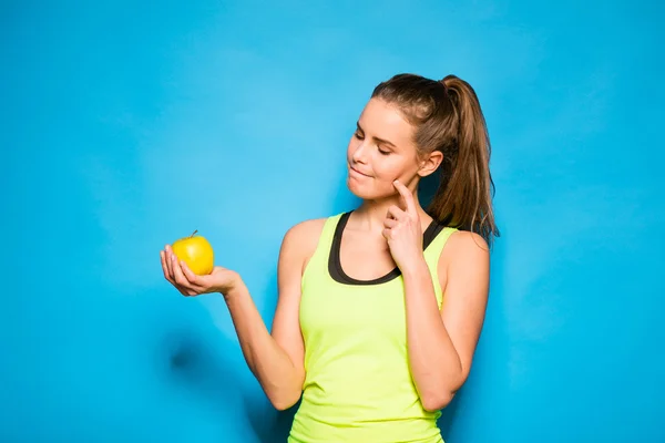 Bonita mujer en equipo deportivo sosteniendo una manzana en la mano — Foto de Stock