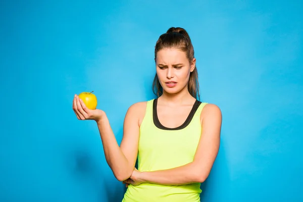 リンゴを手に保持しているスポーツ機器のきれいな女性 — ストック写真