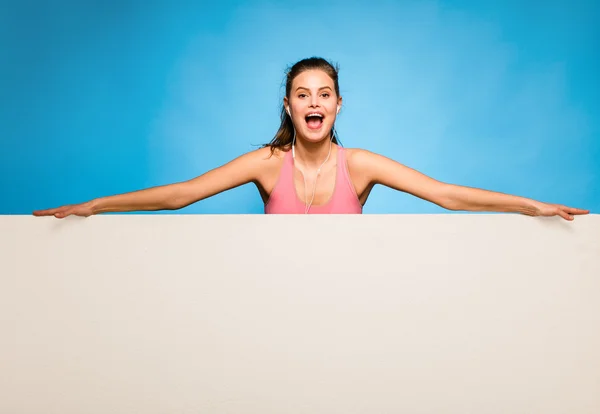 Mujer bonita con auriculares sobre un panel vacío —  Fotos de Stock