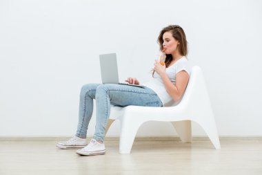 single woman sitting on white chair with laptop clipart