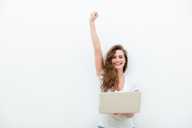 bir dizüstü bilgisayar üzerinde beyaz tutan genç kadın