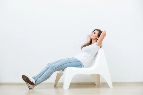 Alleinstehende Frau sitzt auf weißem Stuhl — Stockfoto