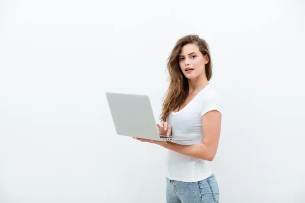 Mujer joven sosteniendo un ordenador portátil en blanco —  Fotos de Stock