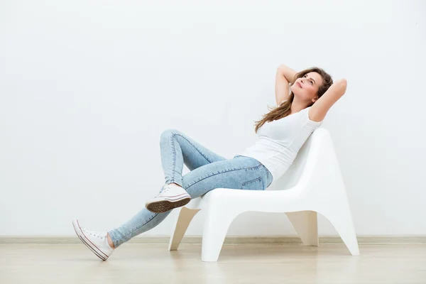 Single woman sitting on white chair — Stock Photo, Image